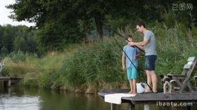 年轻的父亲和他十几岁的儿子一起在淡水塘钓鱼，英俊的爸爸教男孩如何钓鱼
